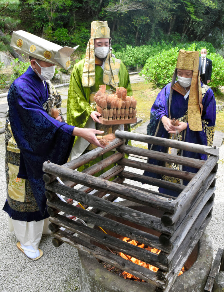 僧侶の読経にあわせて、茶筌を浄焚供養（お焚き上げ）する高梨住職（写真左）（写真提供：朝日新聞社